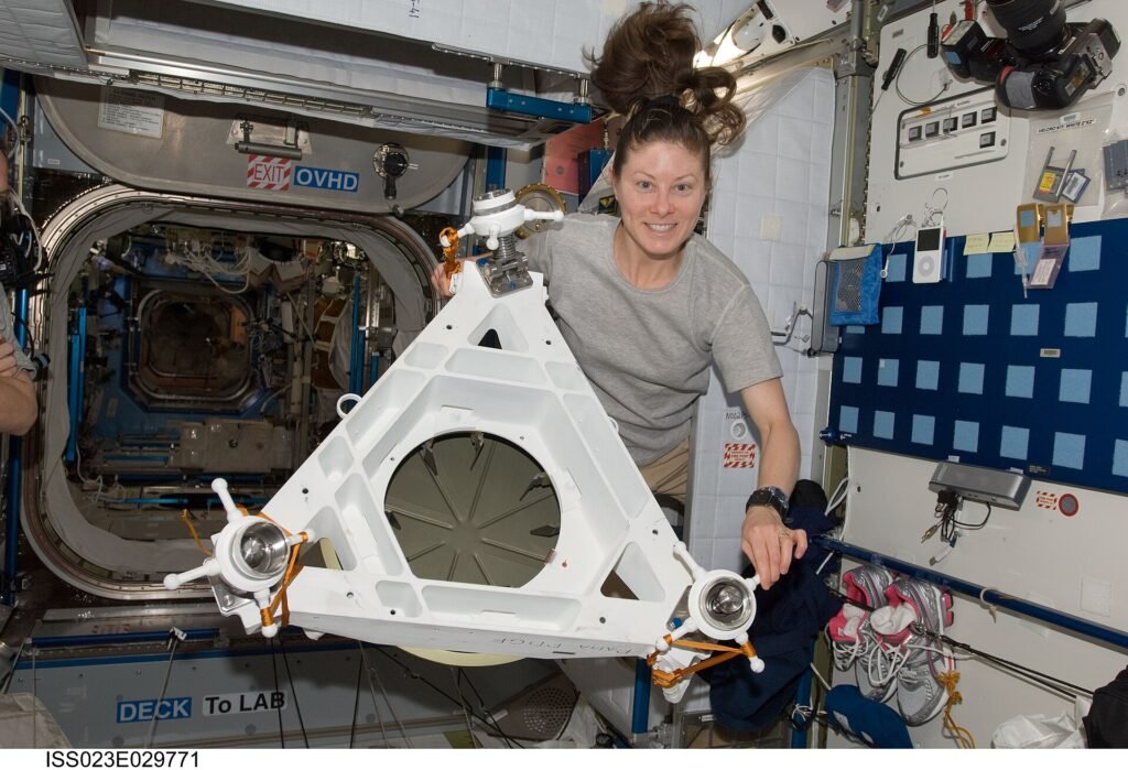 ISS-23 Tracy Caldwell poses for a photo while holding Power and Data Grapple Fixture (PDGF) hardware.jpg
